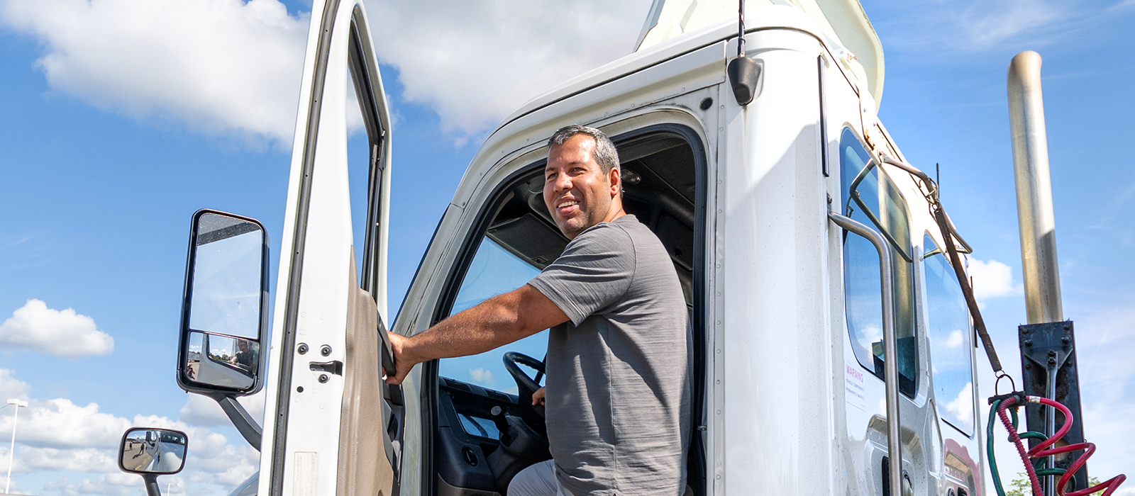 Commercial truck driver climbing into a semi-truck cab as part of CDL training and career pathways.